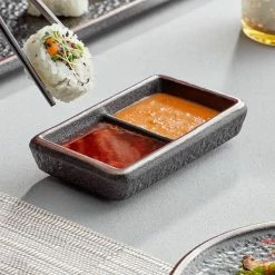Acopa Heika 1 Oz. Black Matte Textured Rectangular 2-Compartment Stoneware Sauce Dish - 12/Case