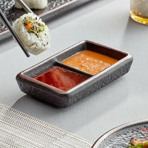 Acopa Heika 1 Oz. Black Matte Textured Rectangular 2-Compartment Stoneware Sauce Dish - 12/Case